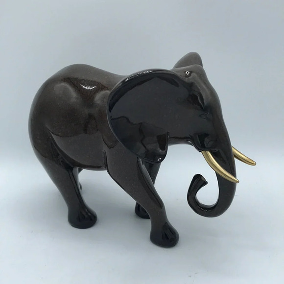Decorative brown elephant figurine with gold-tone tusks and trunk tip - Picture 1 of 6